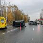 Машина скорой помощи и перевёрнутый автомобиль на мокрой дороге, вдали другие машины и люди, оградительный конус. Тюмень, осень.