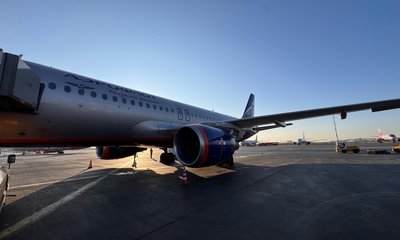 Самолёт «Аэрофлота» стоит на перроне аэропорта на закате.