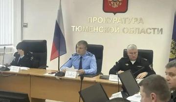 Сотрудники прокуратуры и полиции за столом совещаний под надписью «Прокуратура Тюменской области», гербом и флагом России.
