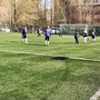 Дети играют в футбол на искусственном газоне.