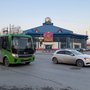 Зелёный автобус и машина на перекрёстке.