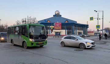 Зелёный автобус и машина на перекрёстке.